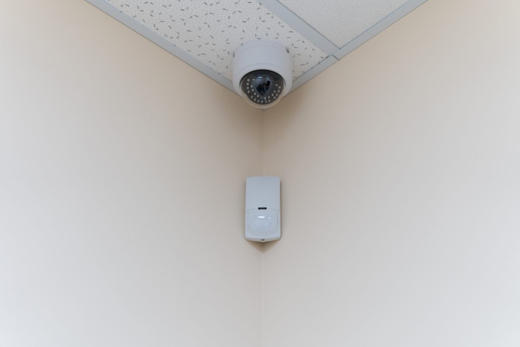Security,Camera,And,Motion,Detector,Installed,On,Ceiling,In,Room motion detector, zabezpecenie budov, security